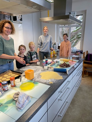 vier Kinder und eine Frau backen Plätzchen